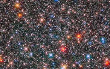Picture of a crowded field of stars some red, some blue of varying brightness