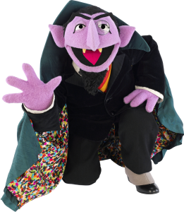 count von count from sesame street kneeling and showing all four fingers on his right hand, possibly having just counted to four or just waving hello